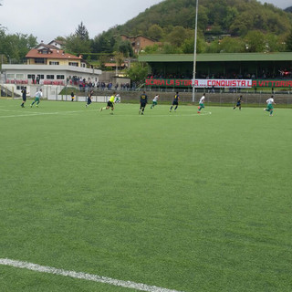 L'inizio della sfida tra Isolese e Sciarborasca. Sullo sfondo, la tribuna con lo striscione dei tifosi dell'Isolese.